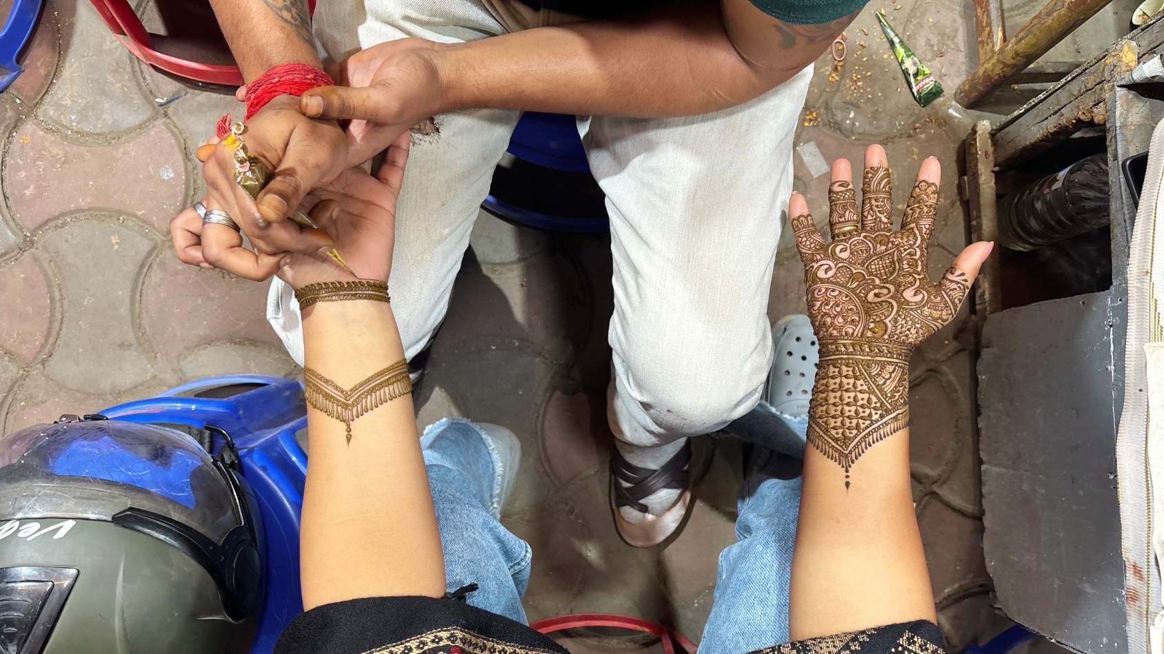 <p>A skilled artist applies Mehendi patterns to a customer's hand.</p>