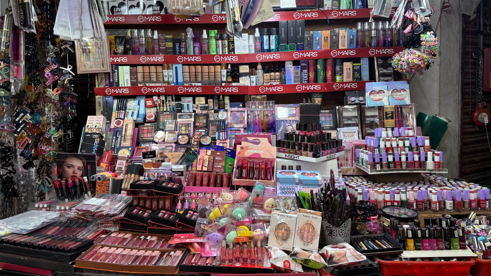 <p>A colourful array of lipsticks, nail polishes, and makeup palettes.</p>