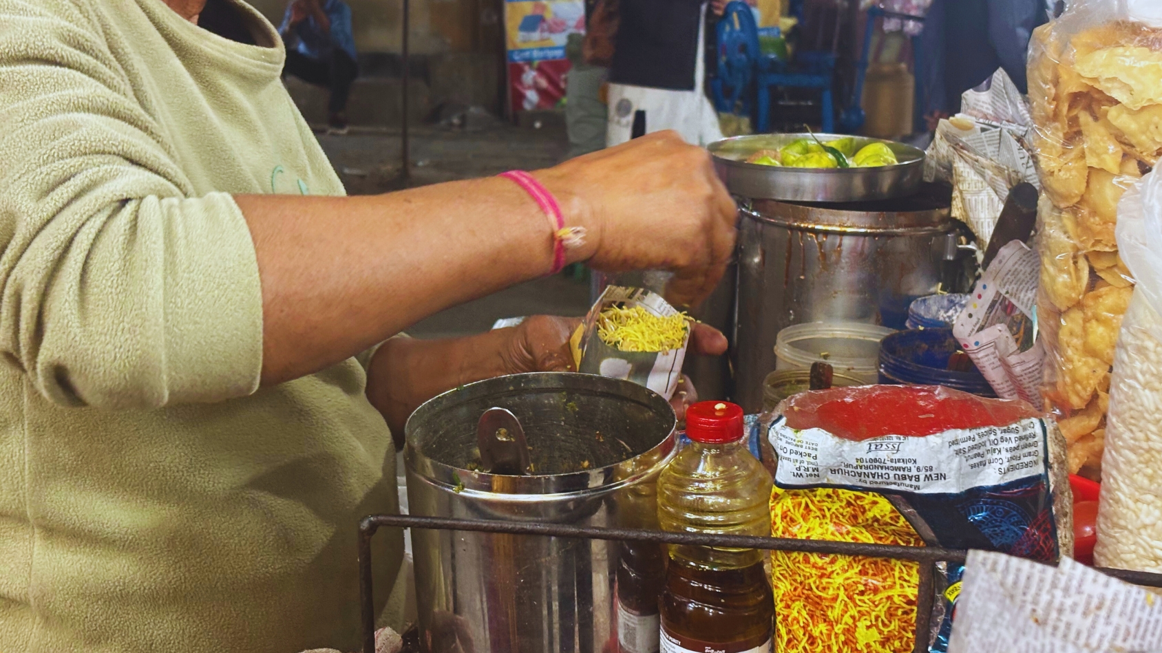 <p>A vendor expertly assembles a fresh serving of jhalmuri.</p>