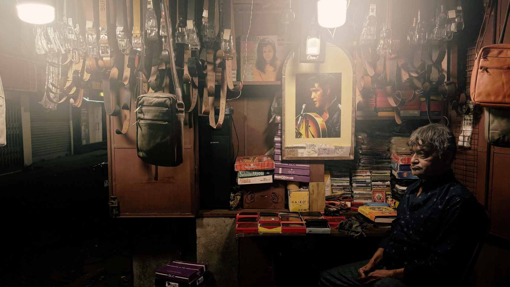 <p>A gentleman sells rugged leather wallets, belts and sling bags alongside an unexpected collection of old cassettes and CDs. </p>